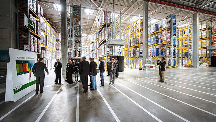 Mensen wonen een presentatie bij in het magazijn van het Lidl distributiecentrum, dat is verlicht door Philips Lighting.