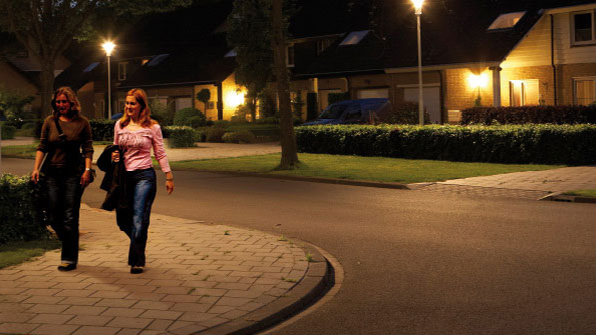 Twee vrouwen wandelen door een straat die is verlicht met wit licht van Philips