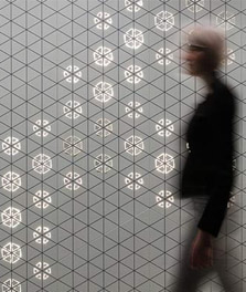 Een vrouw loopt langs een binnenmuur die is verfraaid met Philips Luminous Patterns - klantenbeleving