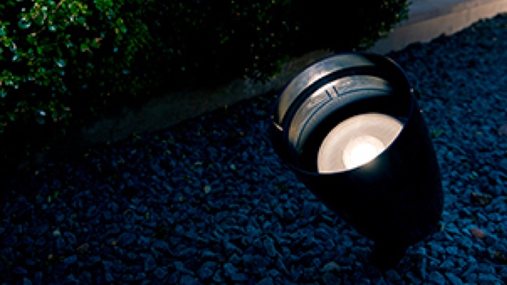 Een Philips LED-schijnwerper die een tuin verlicht