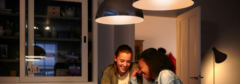 Twee jonge vrouwen die aan een goed verlichte tafel zitten