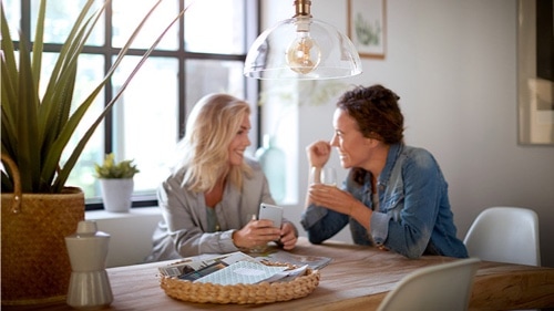 Twee vrouwen die onder een Philips lamp aan het praten zijn