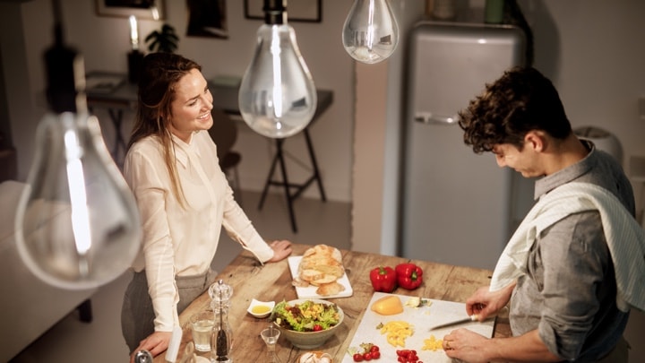 Bovenaanzicht van een man en vrouw die eten koken in een goed verlichte keuken