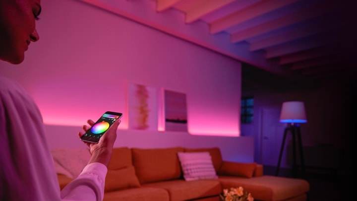 Persoon die gekleurde lampen in de woonkamer bedient