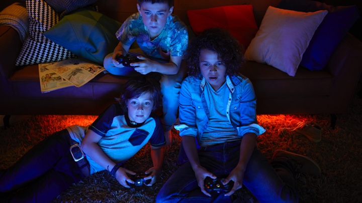 3 jongens spelen videogames met sfeerverlichting