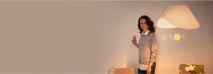 "Vrouw die een slimme dimschakelaar aanpast, en warme LED-verlichtingssfeer regelt in eigentijdse woonruimte met minimalistisch d�cor"