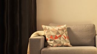 "Gezellige woonkamer met moderne LED tafellamp, die grijze loveseat verlicht en een warme sfeer creëert voor ontspanning thuis."